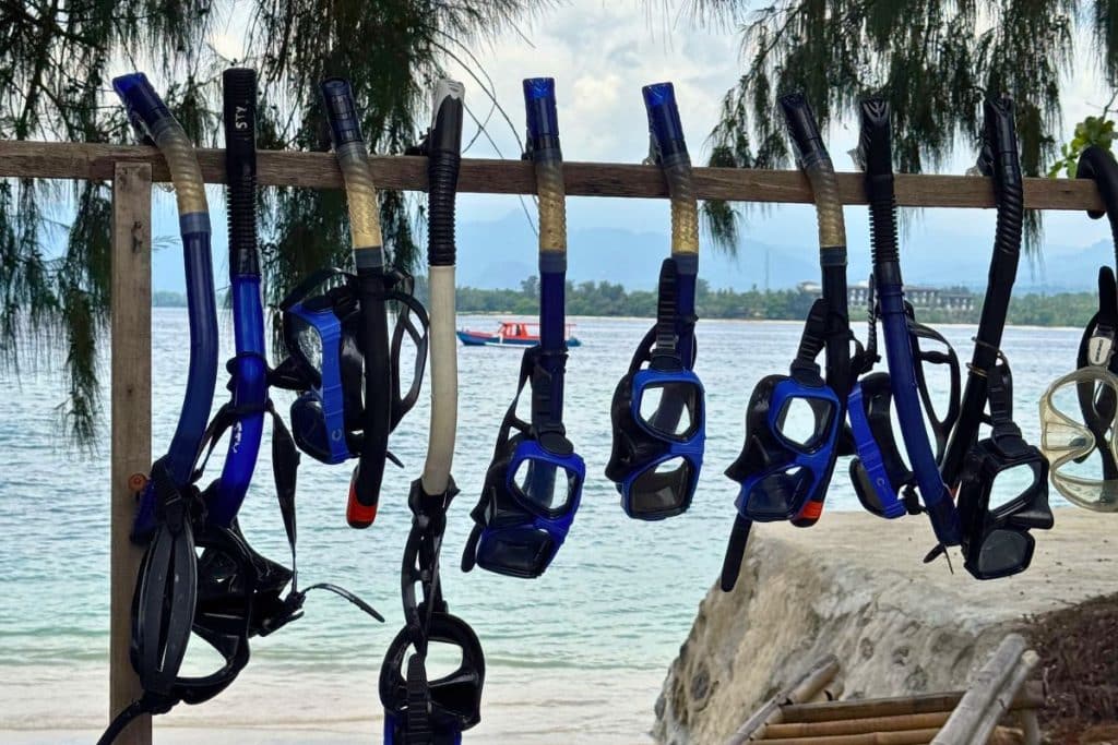 Person snorkeling over coral reef in the clear waters of the Gili Islands