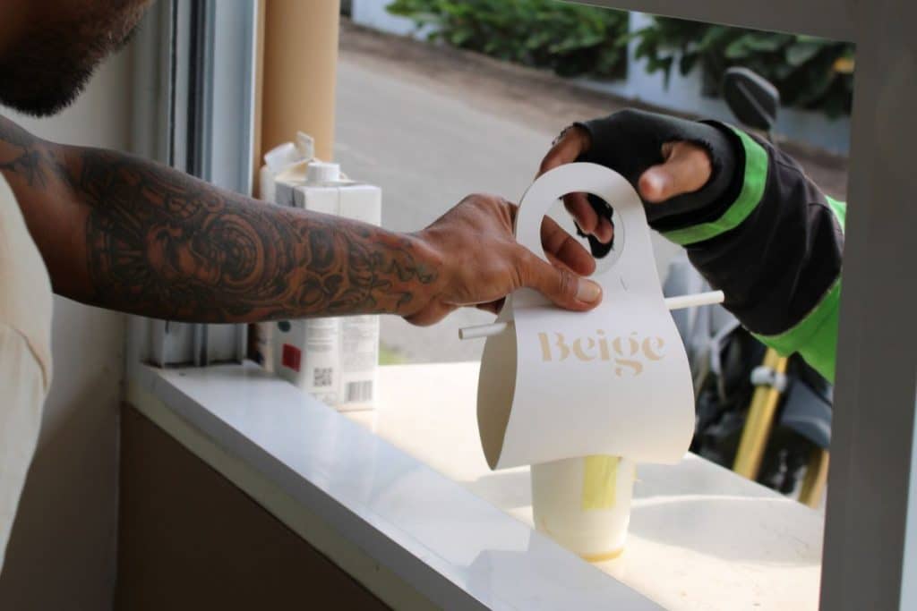 Beige Coffee café with a Gojek motorcycle parked outside