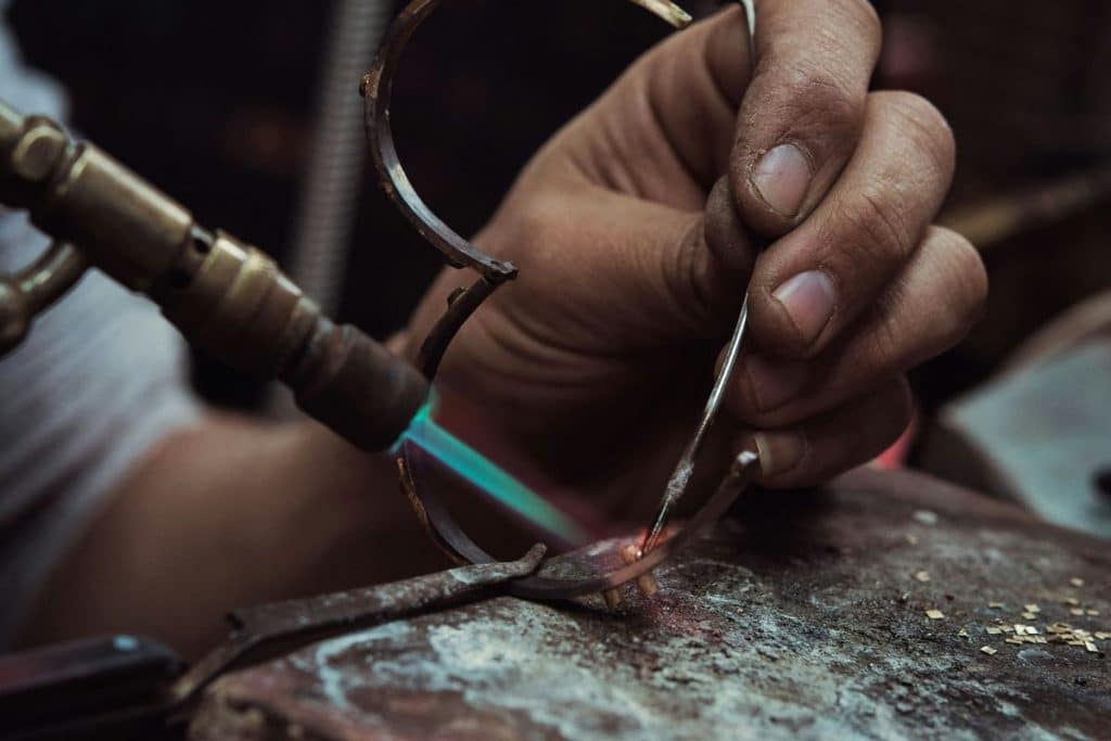 Hands crafting a silver ring during a jewelry-making workshop in Ubud
