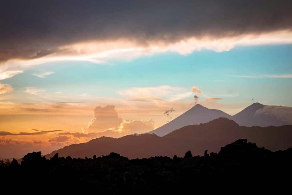 Sunrise view from Mount Batur volcano, Bali — golden light over the crater and surrounding mountains.