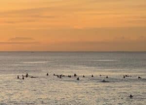 Sunset over Uluwatu beach with surfers in the water, Bali