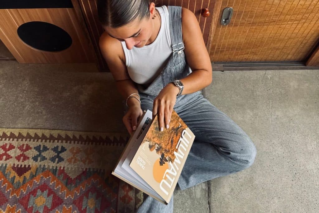 A woman sitting and reading the Uluwatu Travel Guide