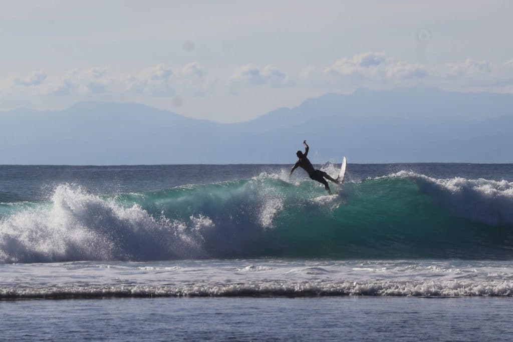 Surfer riding a wave at Canggu beach, Bali