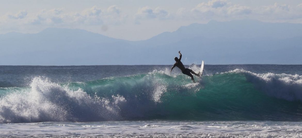 Surfer riding a wave at Canggu beach, Bali