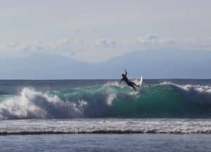 Surfer riding a wave at Canggu beach, Bali