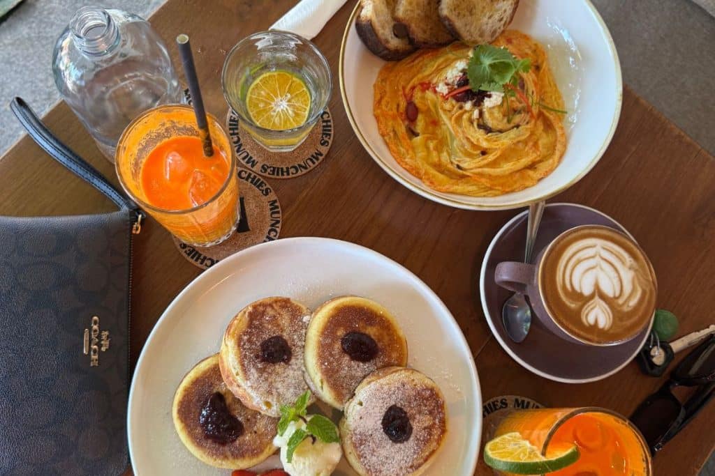 Colorful brunch spread with smoothie bowl, toast, and coffee at a café in Lombok.