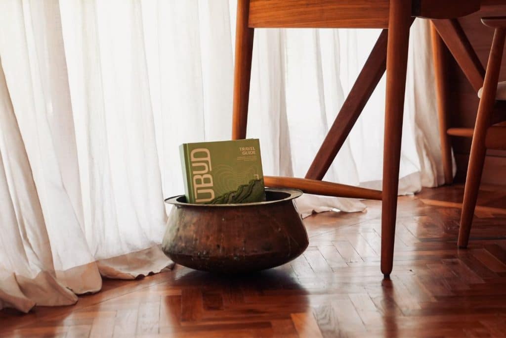 The Ubud Travel Guide displayed inside a villa, elegantly styled in a ceramic pot