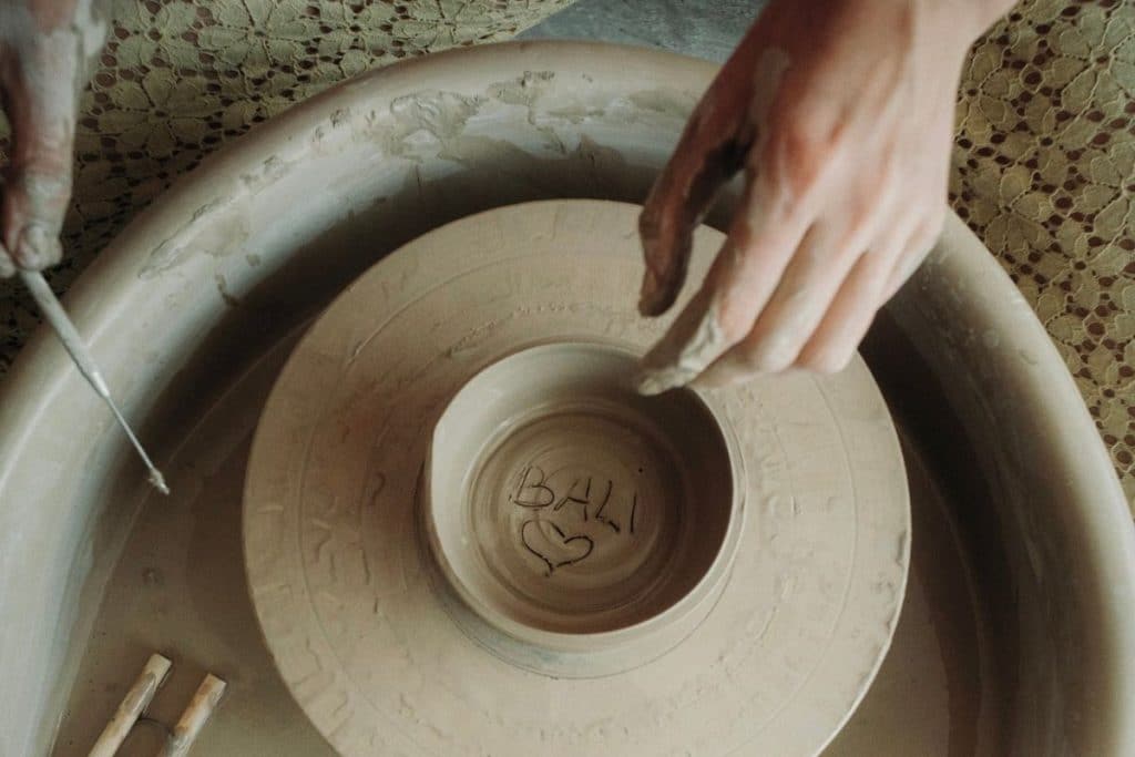 artisan shaping clay on a pottery wheel