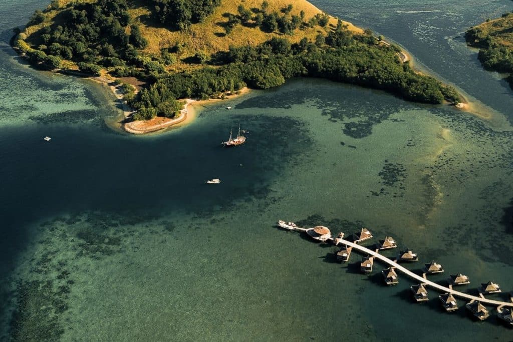 Menjaga Bay Resort drone view Flores Indonesia with overwater villas and turquoise lagoon