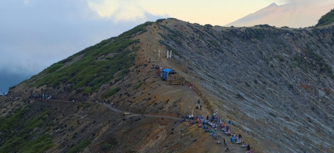Distant view of Mount Ijen volcano with its rugged slopes and lush surroundings in East Java