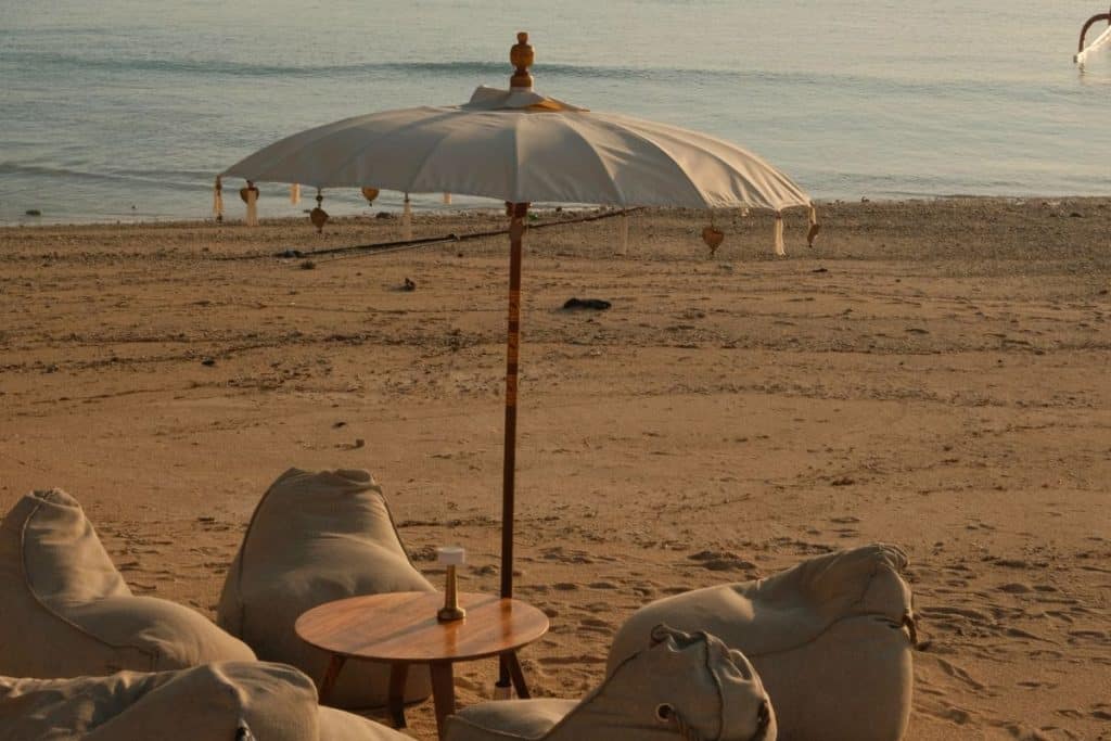 People enjoying cocktails at Sandy Bay Beach Club during golden hour