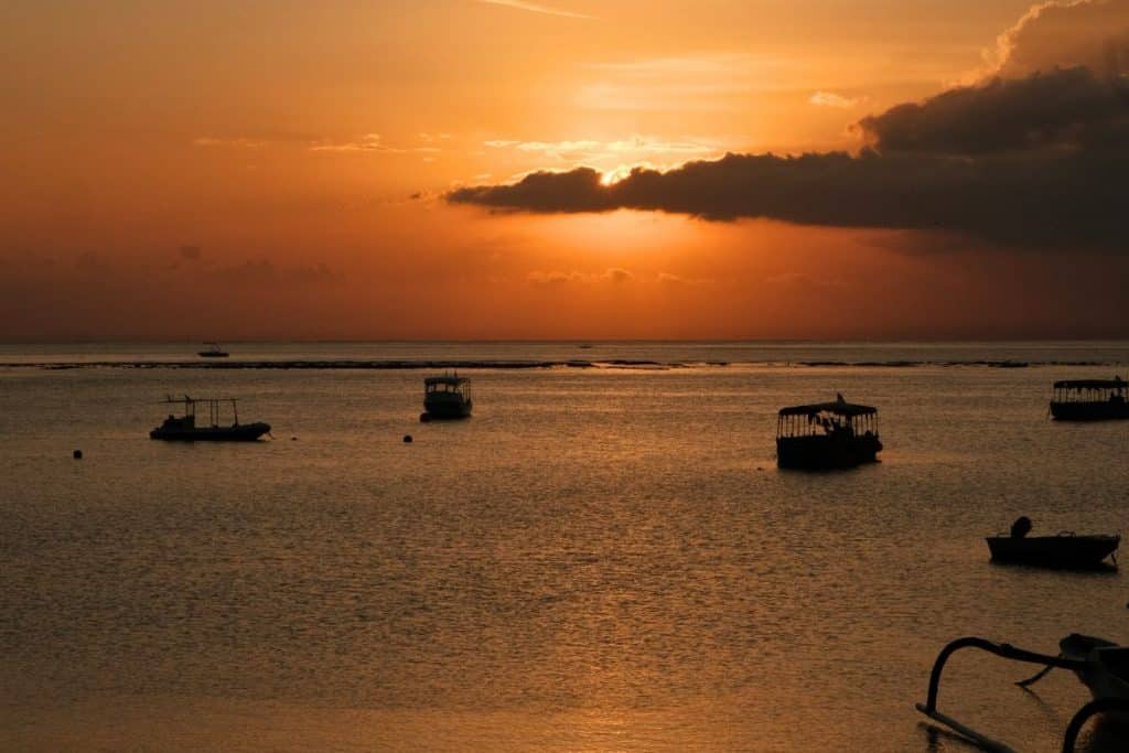 Golden sunset casting light over the cliffs and waves at Sunset Beach, Nusa Lembongan