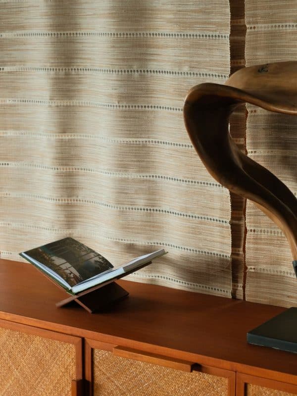 Wooden bookstand with book styled on console table in home interior