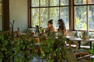 People working inside Kalos Bali café surrounded by greenery