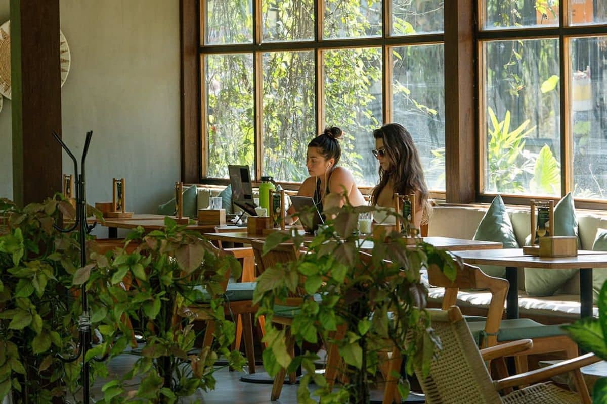 People working inside Kalos Bali café surrounded by greenery