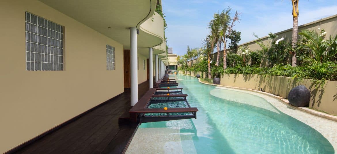 Outdoor pool area at Sini Vie Villa Seminyak with greenery and modern architecture.