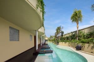 Outdoor pool area at Sini Vie Villa Seminyak with greenery and modern architecture.