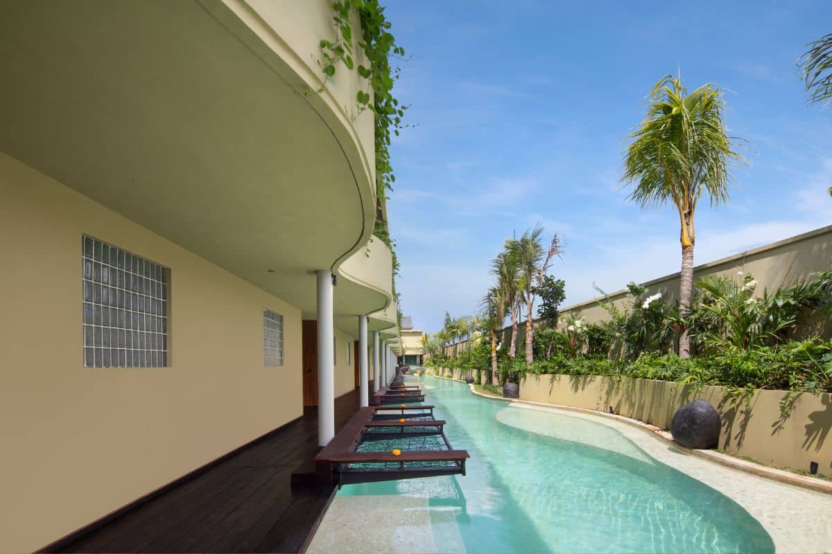 Outdoor pool area at Sini Vie Villa Seminyak with greenery and modern architecture.