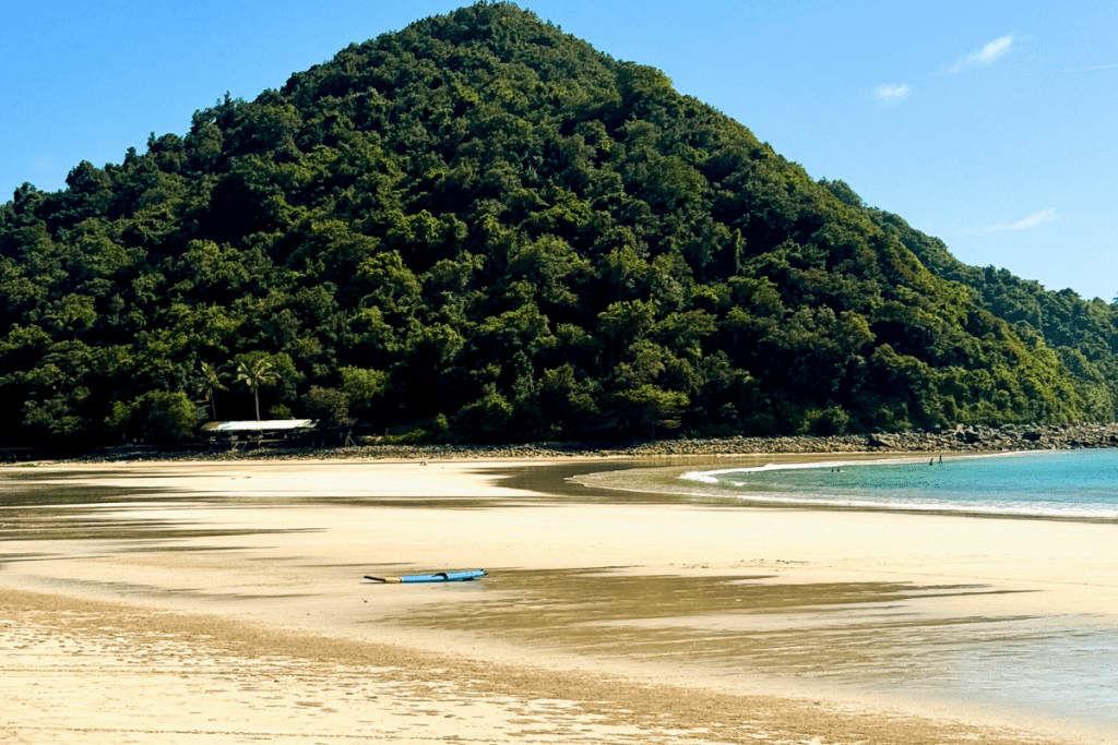 Selong Belanak Beach in Lombok with a wide white sand bay surrounded by green hills
