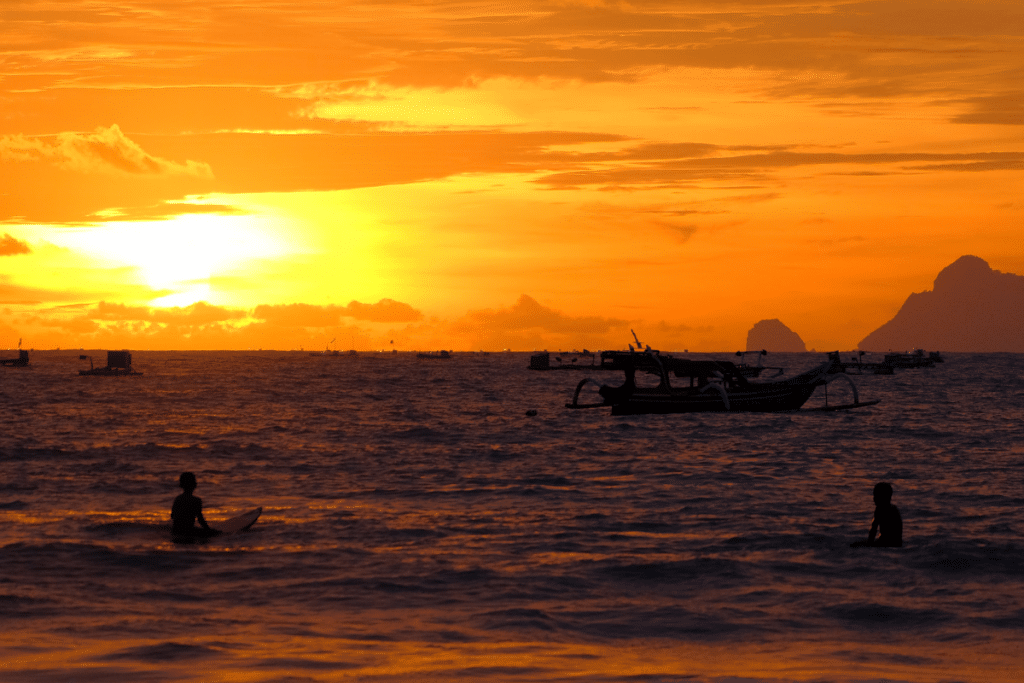 Sunset over a beach in Lombok with warm golden light reflecting on the ocean
