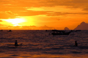 Sunset over a beach in Lombok with warm golden light reflecting on the ocean