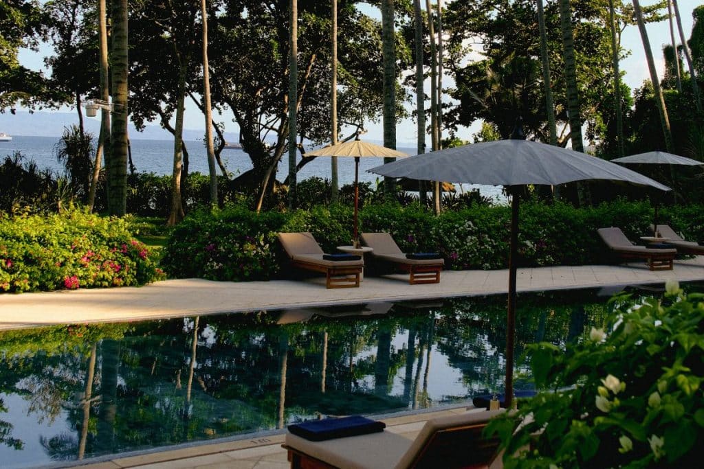 Amankila Bali pool near the beach with palm trees