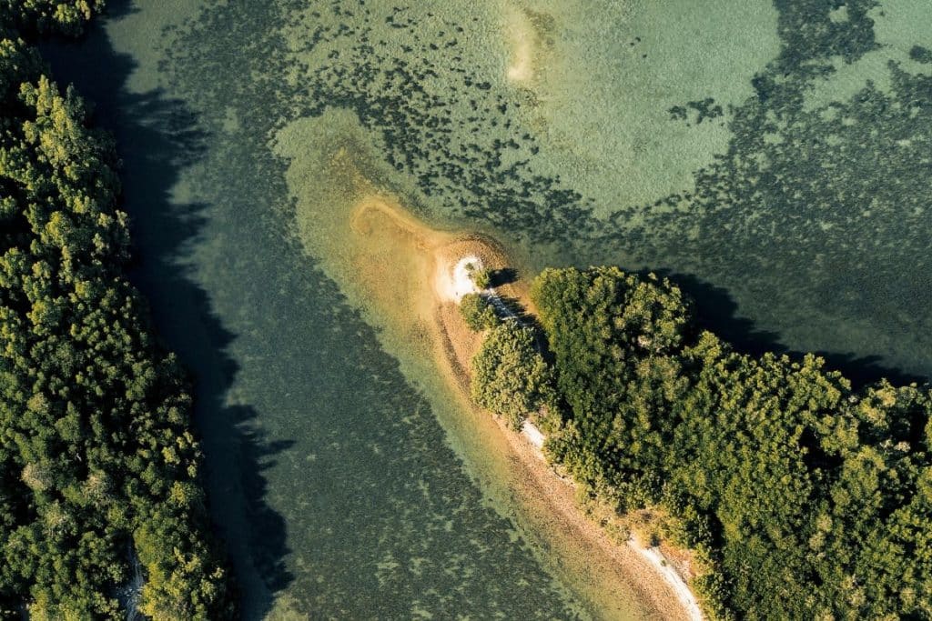 Aerial view of small islands and clear waters around Menjaga Bay