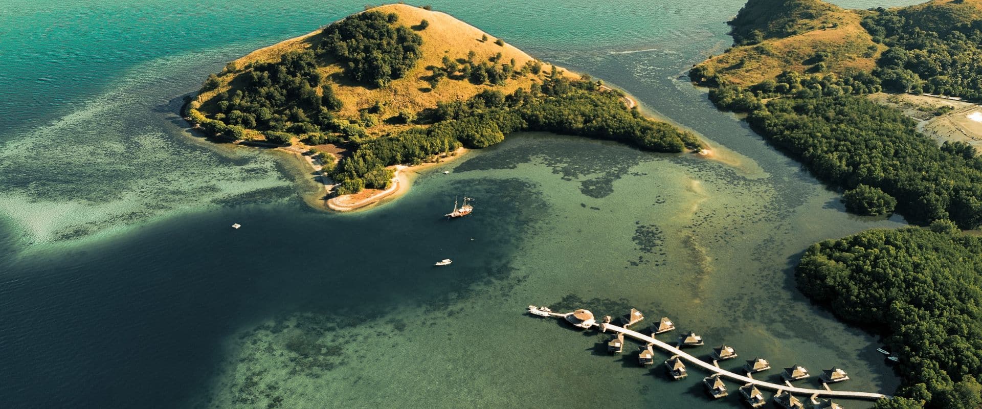 Aerial view of Menjaga Bay Resort surrounded by jungle and coastline in Bali