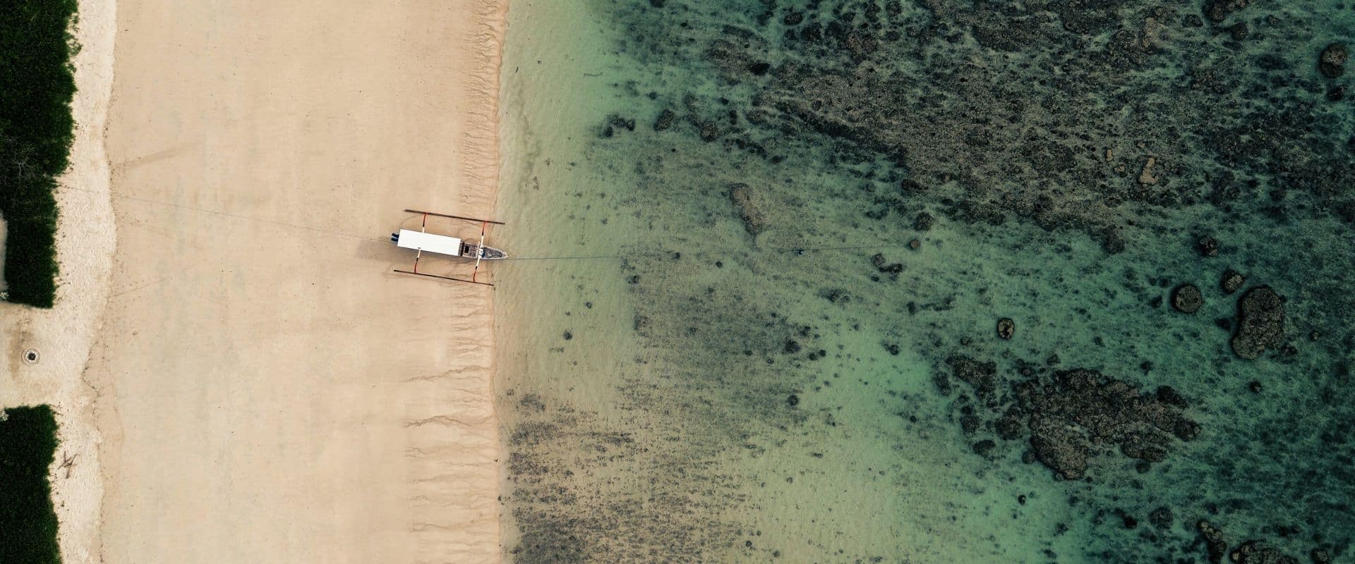 sumba beach aerial view with boat on turquoise water