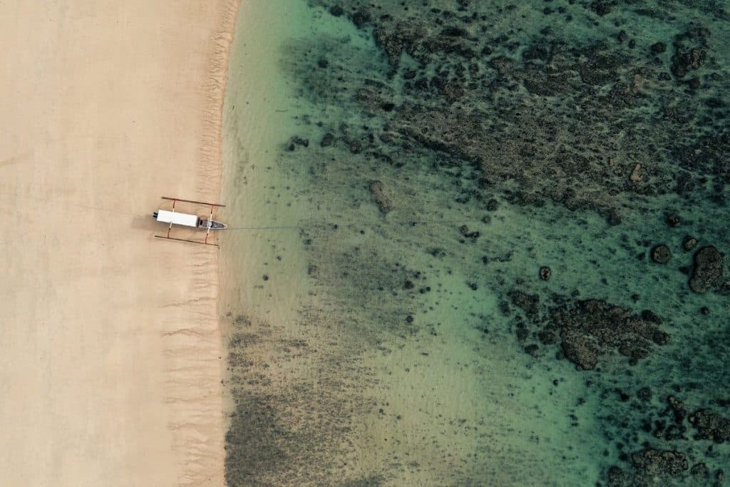 sumba beach aerial view with boat on turquoise water