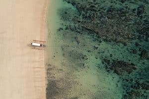 sumba beach aerial view with boat on turquoise water