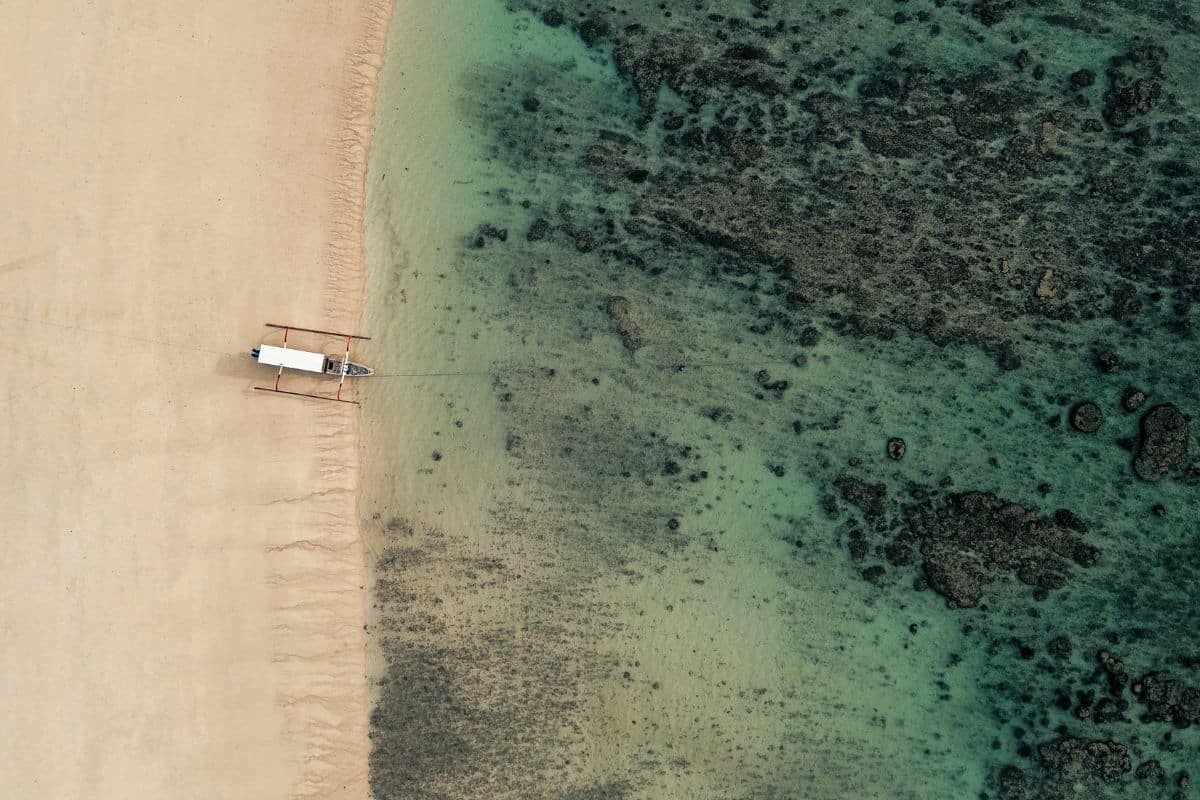 sumba beach aerial view with boat on turquoise water