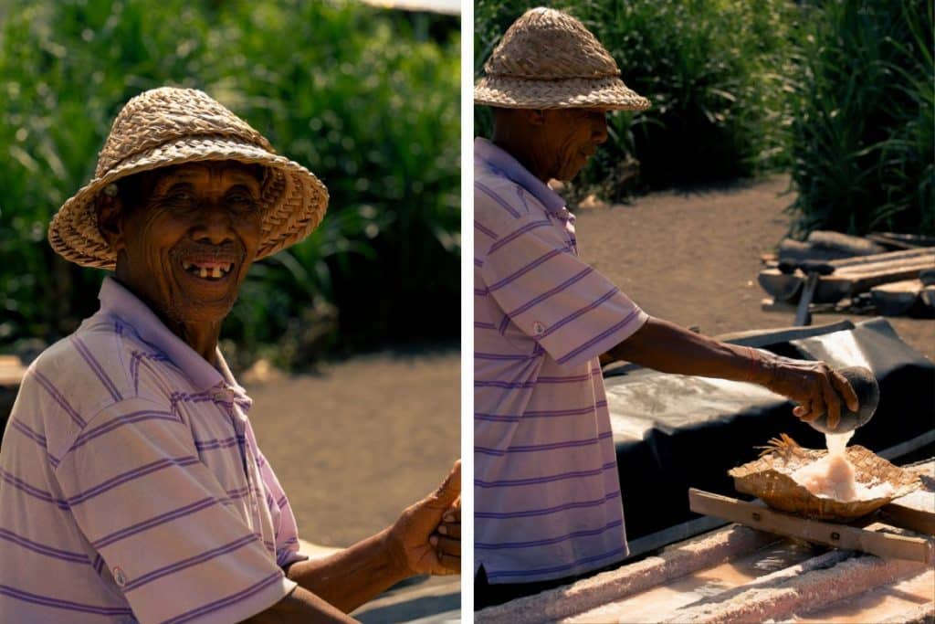 Local salt farmer showing traditional salt evaporation basins in Bali