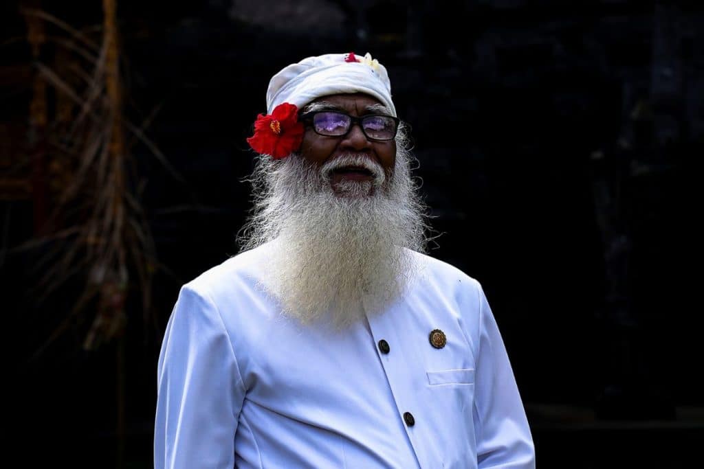 Balinese priest leading a Hindu temple ceremony during Kuningan in Bali.