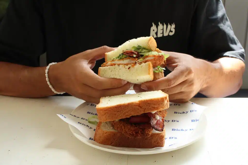 Man holding a sandwich from Ricky Sandwich Bali.