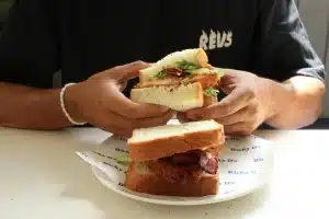 Man holding a sandwich from Ricky Sandwich Bali.