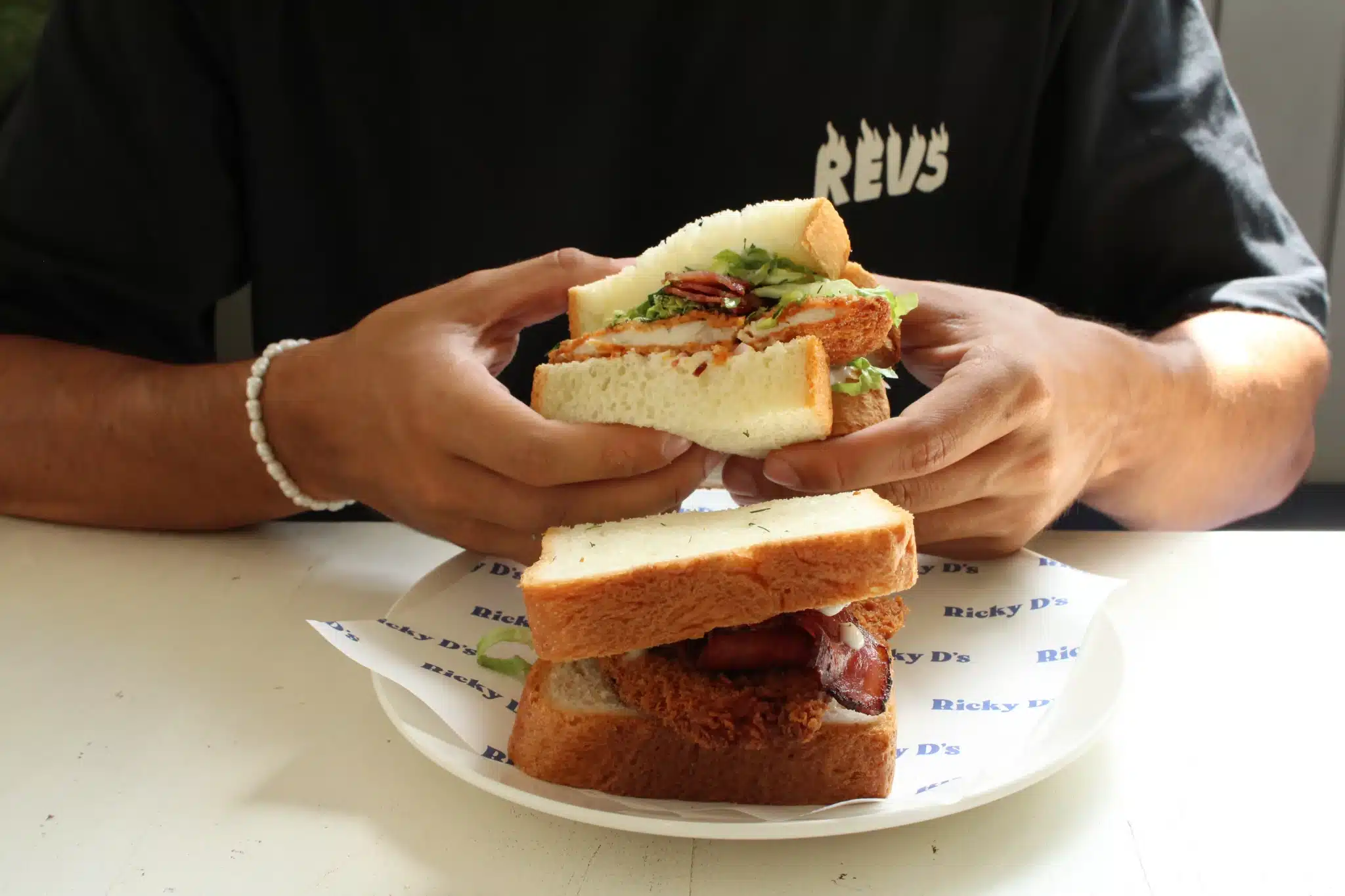Man holding a sandwich from Ricky Sandwich Bali.