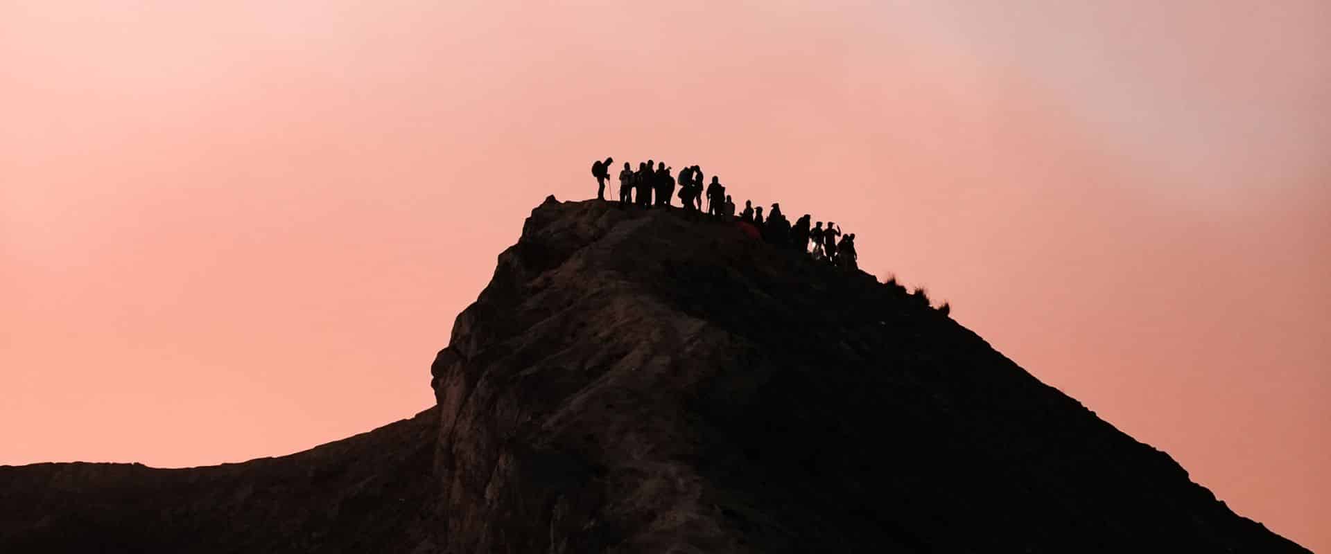 Hikers trekking on a Bali volcano at sunrise with panoramic mountain views