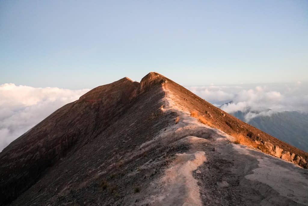 Hikers climbing Mount Agung before sunrise with headlamps along the trail