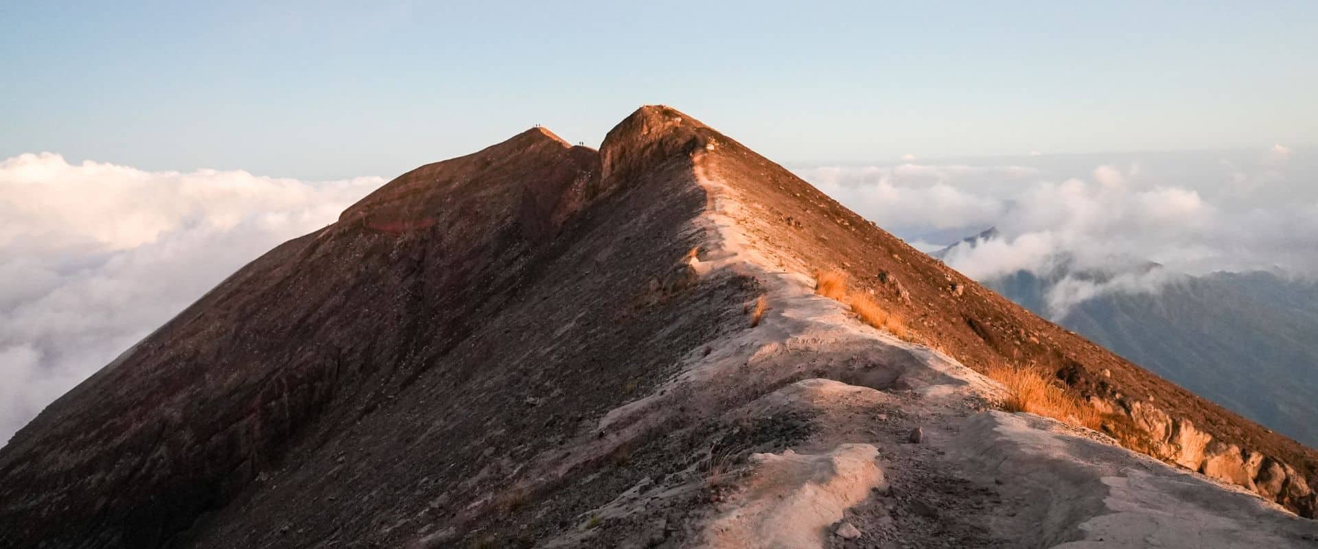 Hikers climbing Mount Agung before sunrise with headlamps along the trail