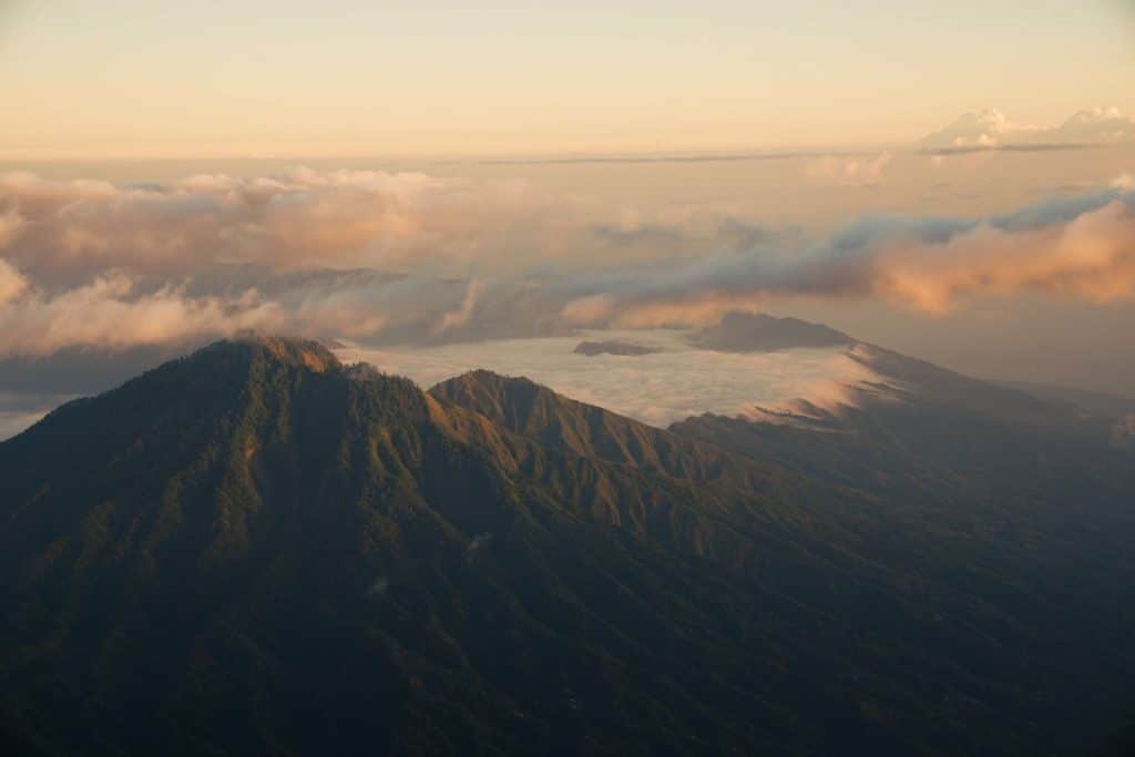 View of Mount Batur rising above a sea of clouds from the summit of Mount Agung