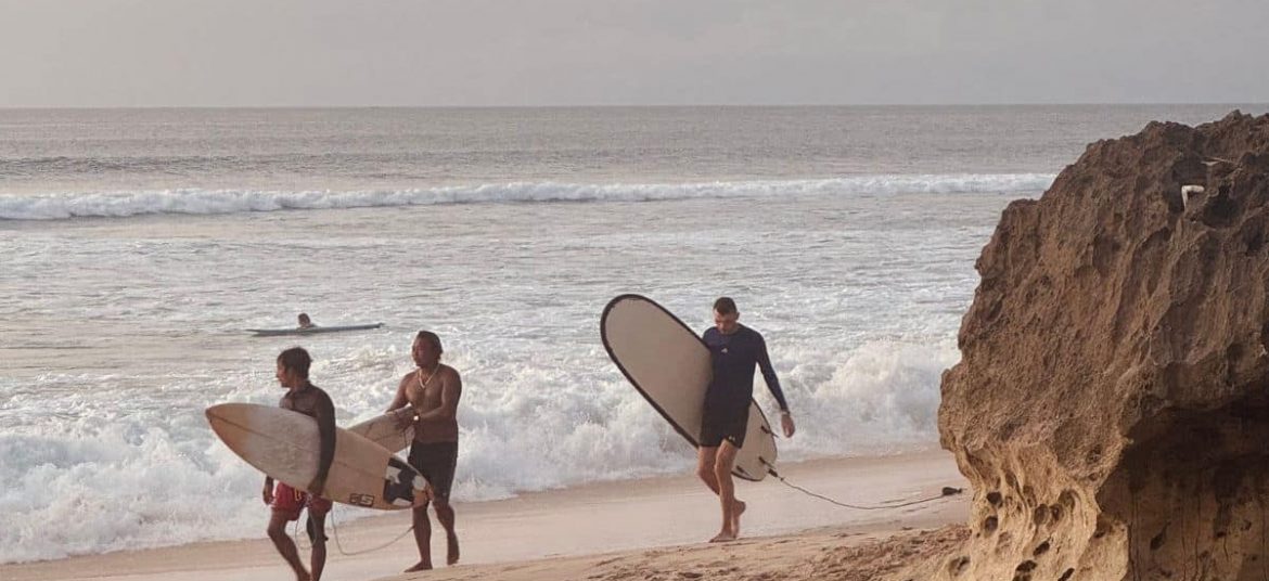 Surfer riding a wave at Dreamland Beach in Uluwatu, Bali.