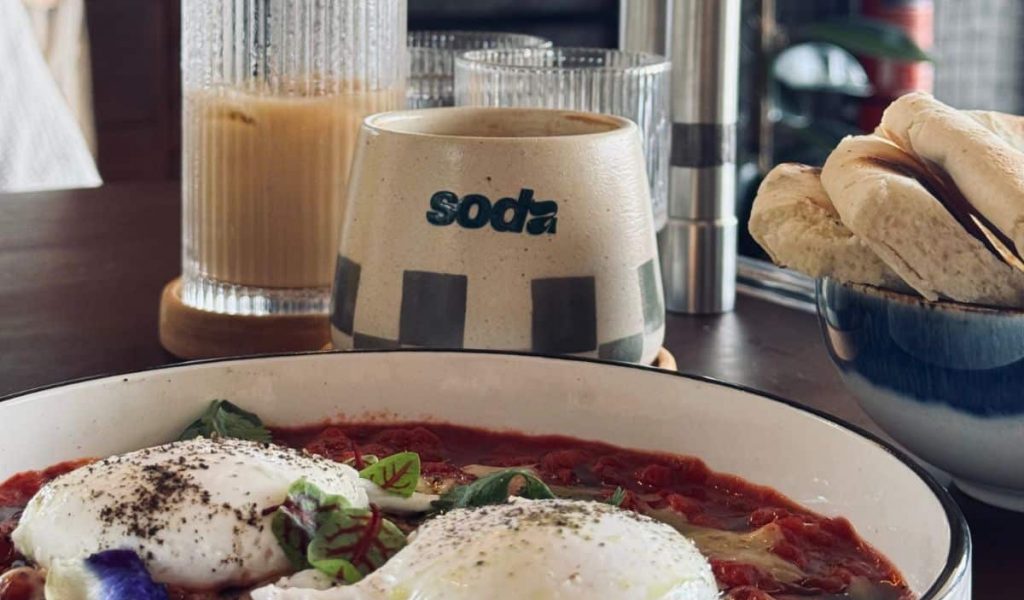 Colorful breakfast plates with smoothie bowls and toast at Soda café