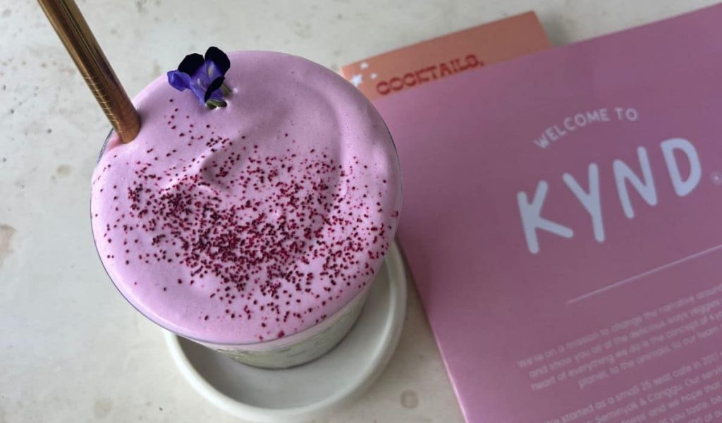 Bright green matcha and colorful menu at Kynd Community.