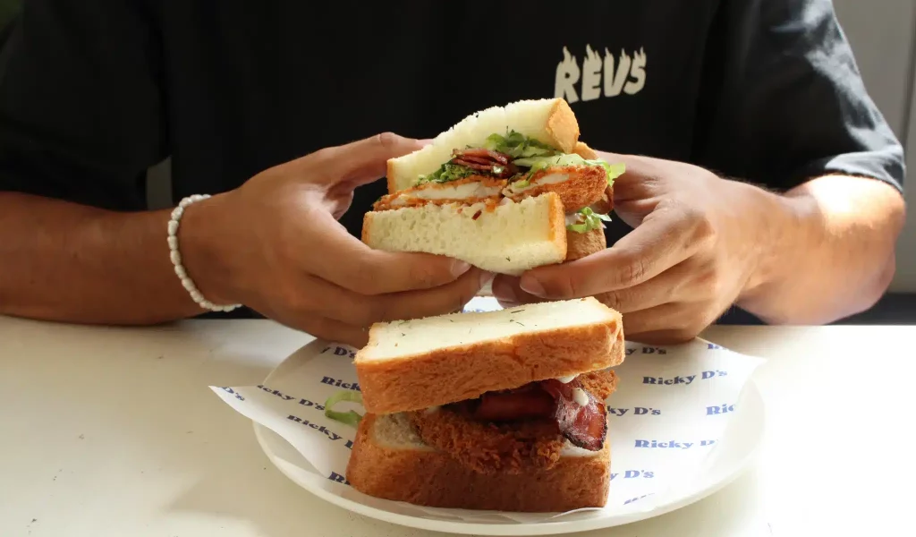 Man holding a sandwich from Ricky Sandwich Bali.