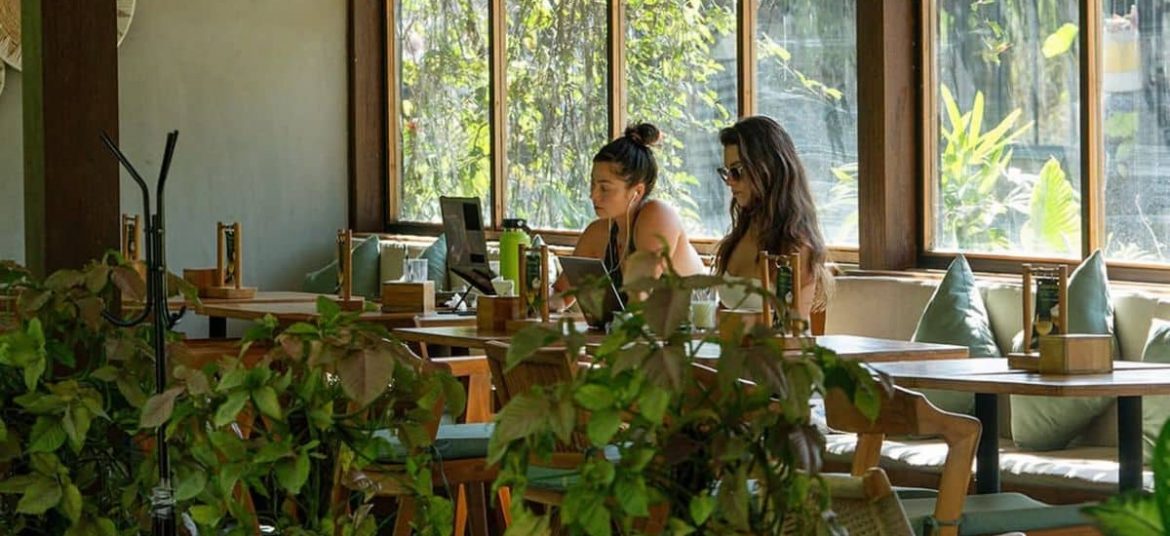 People working inside Kalos Bali café surrounded by greenery