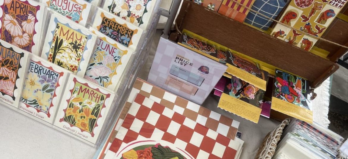 Handmade postcards and illustrated souvenirs displayed by a local vendor at a market in Uluwatu