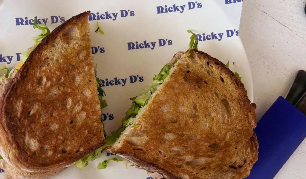 Man holding a sandwich from Rickies Sandwich Bali.