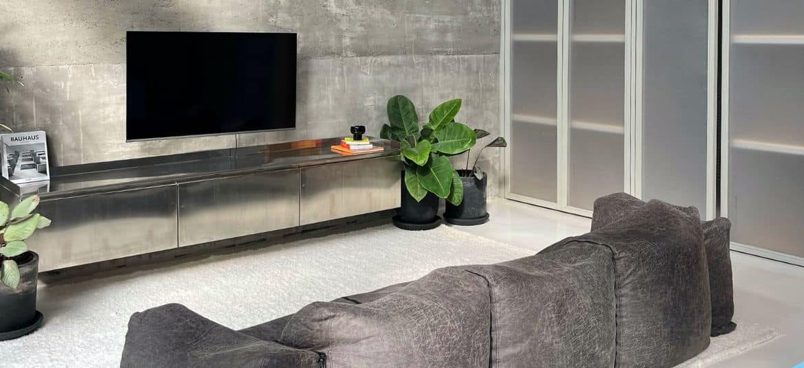 Industrial-style living room at Sojourn Spaces in Canggu featuring raw concrete walls, minimalist furniture, and natural light