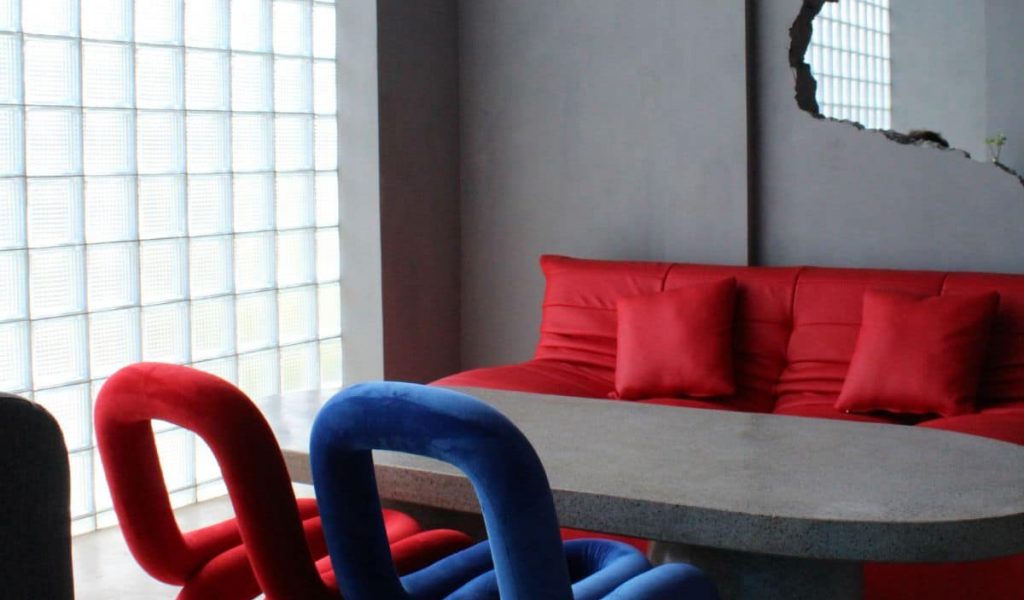 Industrial-style café interior at SOZD in Canggu featuring raw concrete walls, small grid windows, and minimalist design